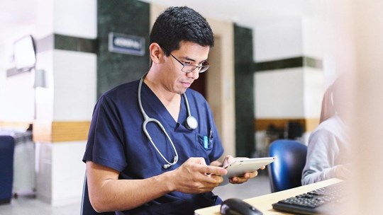 Young medical doctor is using an ipad tablet doing administration and medical healthcare reports