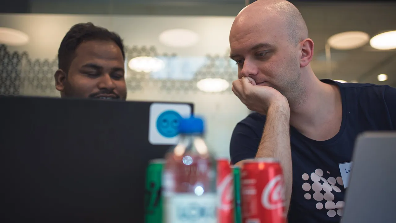 Two men attending a hackathon in an office space